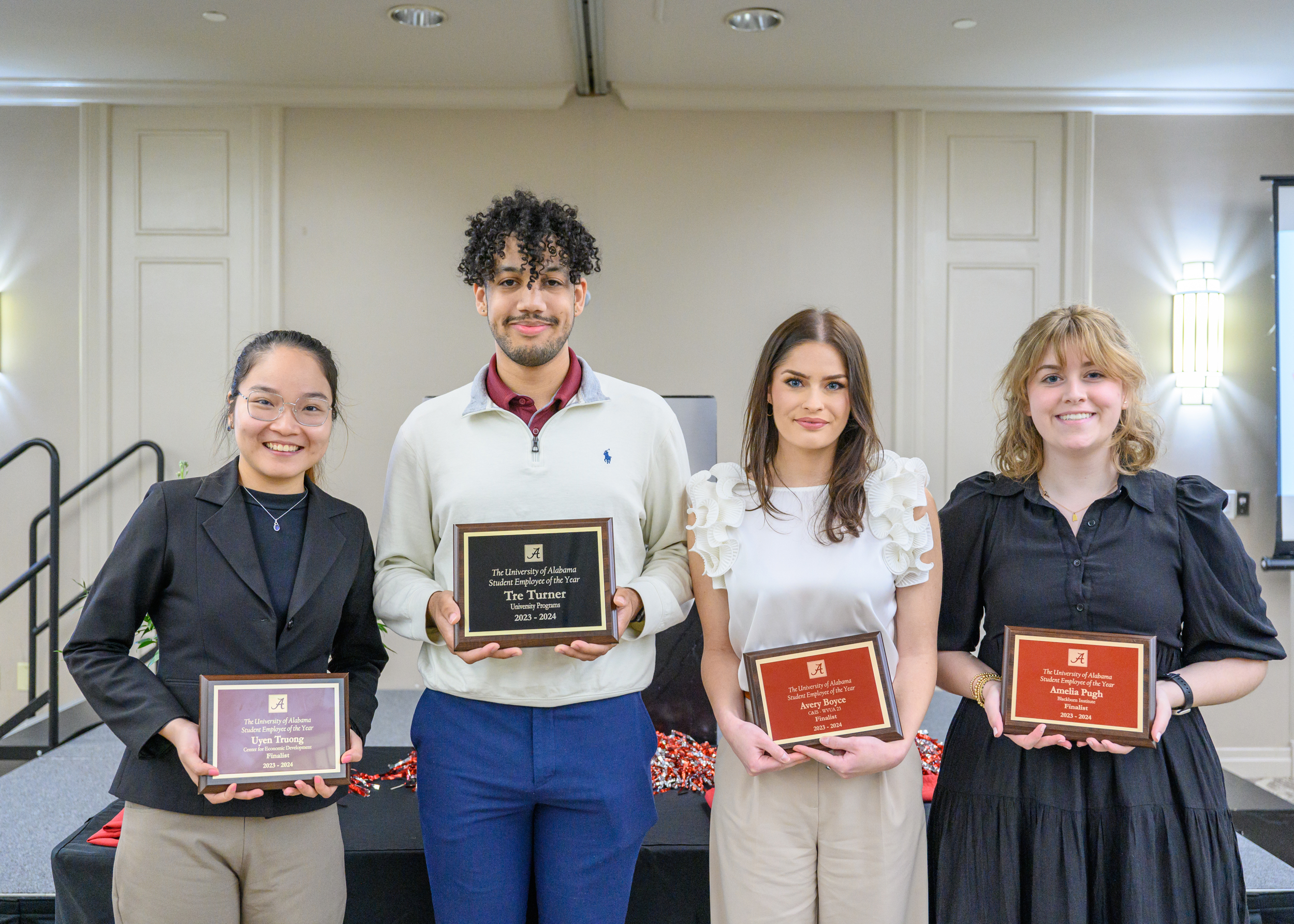 students holding award plaques at an event